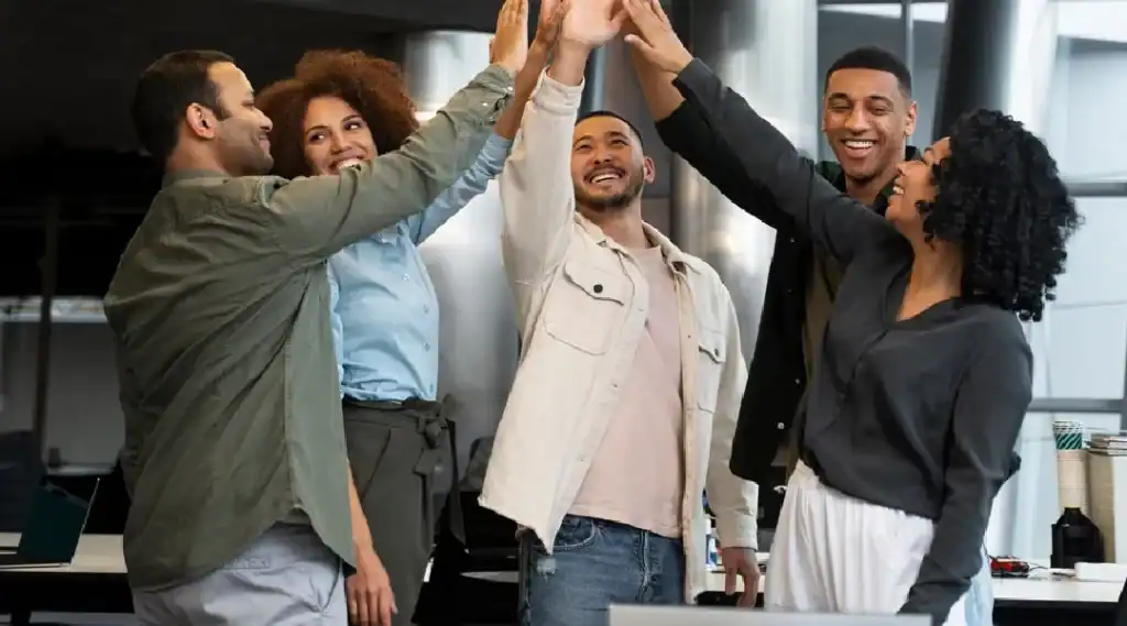 Diverse team celebrating success in a modern office environment.